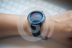 Smart watch at womanÃ¢â¬â¢s hand checking heart rate at the office photo